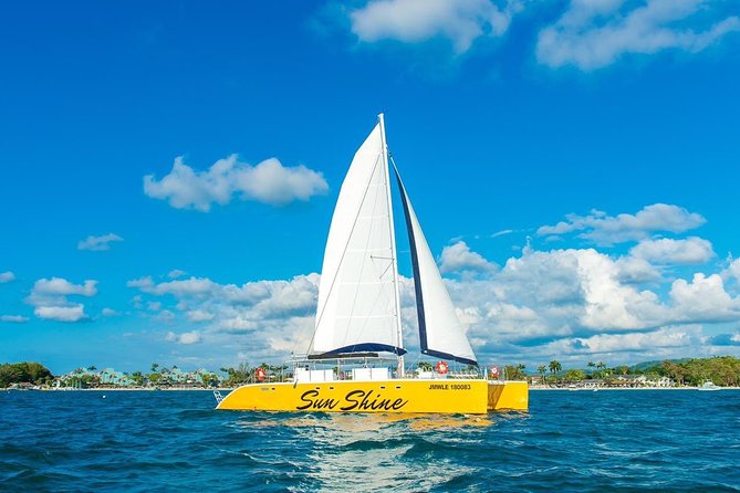 Catamaran Cruise Full Day Tour to Reef, Caves and Negril Beach - Sailing past Rick’s Cafe at sunset